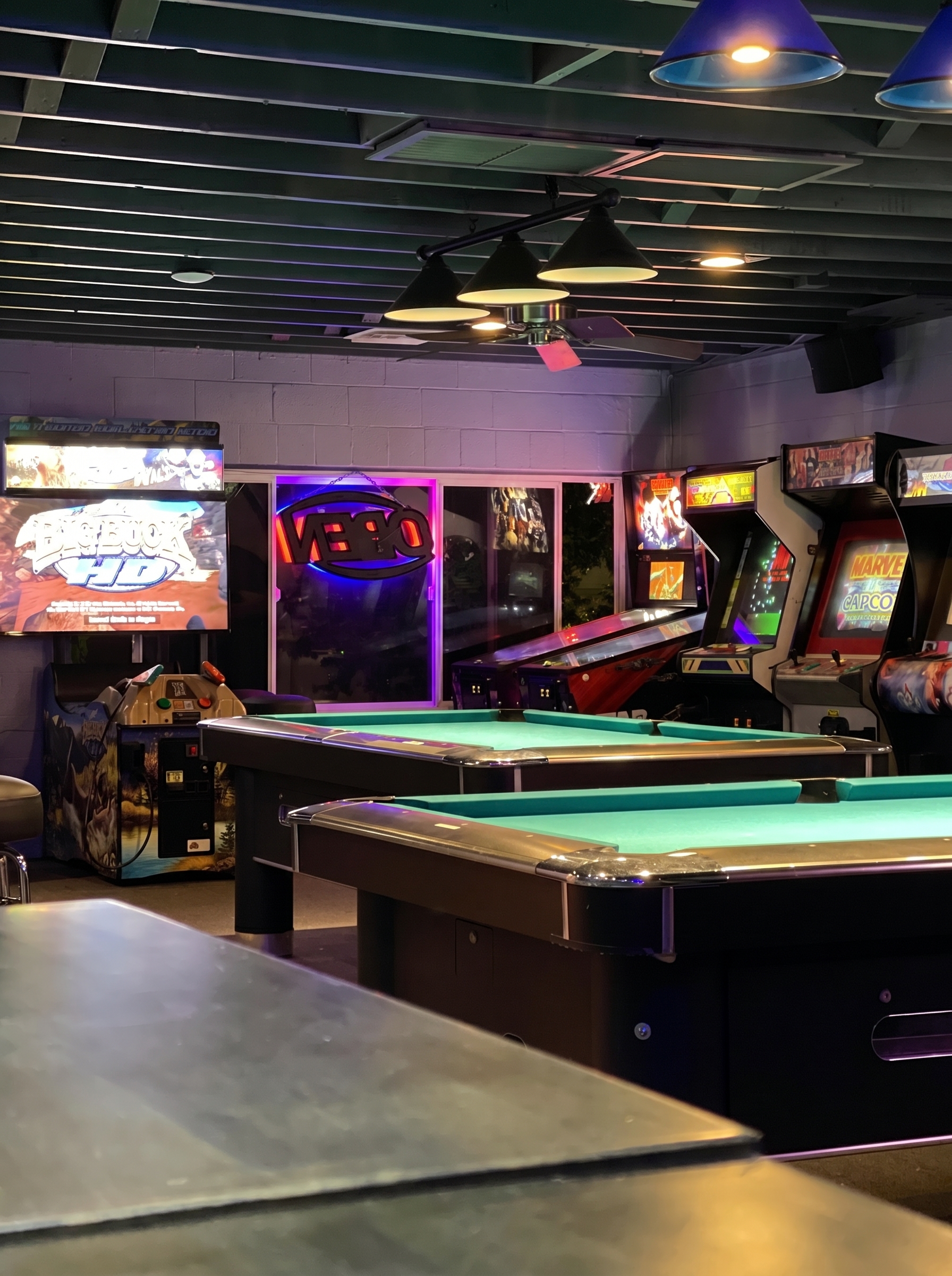 The back room at The Blue Moon: two pool tables, Marvel vs Capcom and Big Buck Hunter HD arcade cabinets